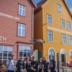 Grupo diante das casas coloridas de Bryggen em Bergen, Noruega